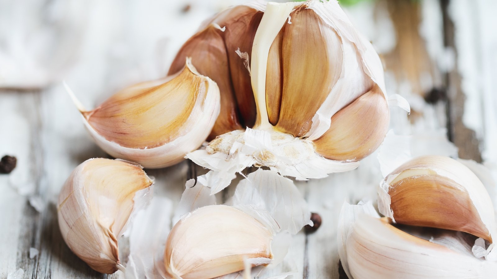 A close-up of Allium sativum cloves, showcasing their papery skins and varied sizes.